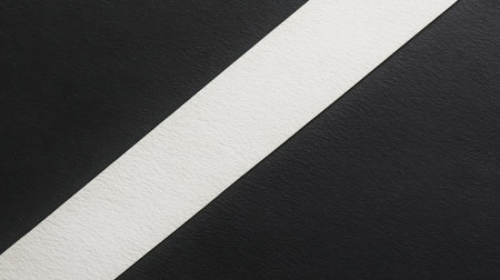 A striking minimalist abstract background showcasing a white stripe on a textured black surface, ideal for artistic projects and modern design applications.の素材