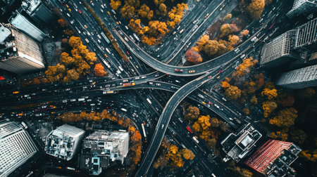 This captivating aerial image captures a busy urban highway intersection surrounded by vibrant autumn foliage and tall buildings, showcasing the dynamic city life.の素材