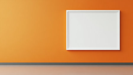 This image features a minimalistic interior showcasing an empty white frame mounted on a bold orange wall, creating a vibrant and modern atmosphere.の素材