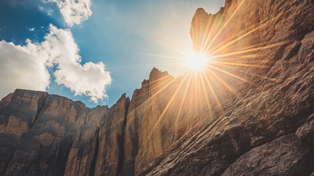 This stunning image captures a majestic mountain landscape, featuring sunlight piercing through clouds over rugged rock formations, showcasing nature's raw beauty and serenity.の素材