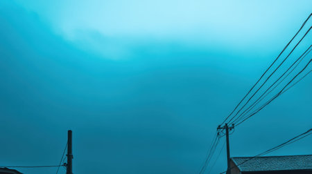 A captivating urban landscape featuring a moody electric blue sky with silhouetted structures and power lines, evoking a sense of tranquility and contemplation.の素材