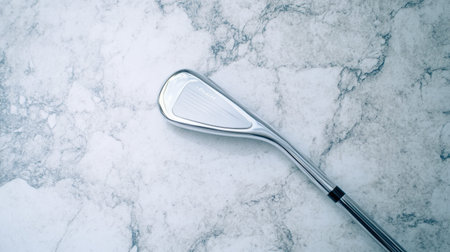 A close-up view of a golf club iron resting on a beautiful marble surface. The photo captures the shiny metal details, evoking a sense of elegance and precision in sports.の素材