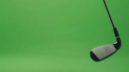 This image features a close-up view of a golf club against a vibrant green background, perfect for showcasing sports or leisure themes in your projects.の素材
