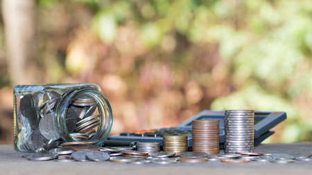 Coins or money on calculators, financial accounting concepts and save money.の写真素材