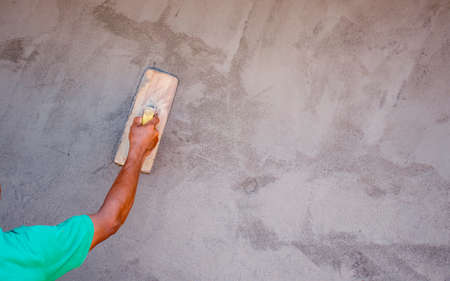Close-up of workers using plaster trowel to plaster the walls for house construction, working ideas, and residential construction.の写真素材