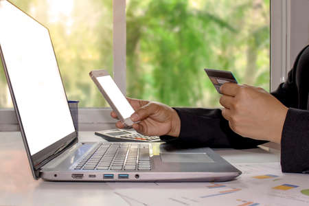 Women with credit cards and mobile phones, including laptops for working on desks, e-commerce concepts, internet banking and online shopping.の写真素材