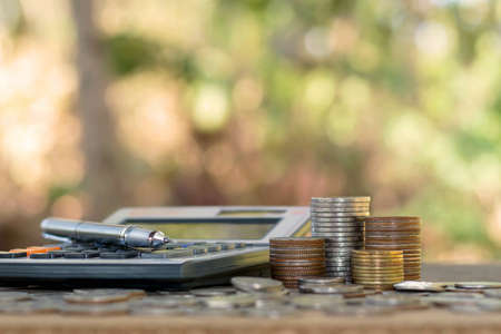 Coins or money on calculators, financial accounting concepts and save money.の写真素材