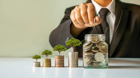 Planting a tree on a pile of money and businessman, man saving money, money saving ideas for future investment.の写真素材