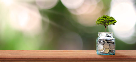 Financial business background. Planting a tree on a coin bottle and wood floor. Financial and...
