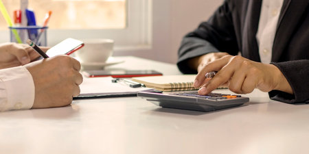 Business women and colleagues who pressed a calculator to calculate office expenses.の写真素材