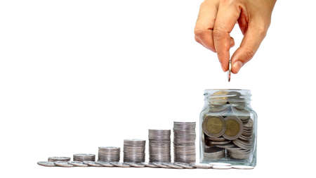 Hand holding coin put into money saving bottle on white background money saving idea to invest in...