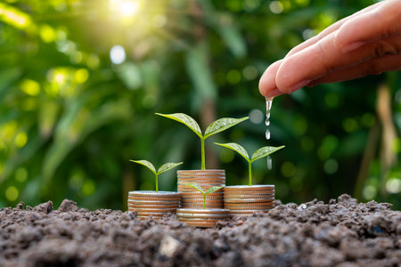 Farmer's hands are watering plants on stacked coins and naturally blurred background, SME financial growth, and investment concept.の写真素材
