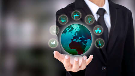 Energy Business Investment Ideas environmentally friendly clean energy icon and the globe in the hand of a businessman wearing a suitの写真素材