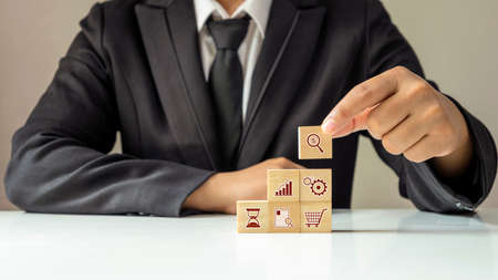 businessman laying out the financial business icon on the wooden cube, financial concept Business Growth, and Small Business Event Planningの写真素材