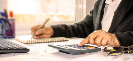 Businesswoman checking accounts and finances to calculate invoices in the office. Audit concept.の写真素材