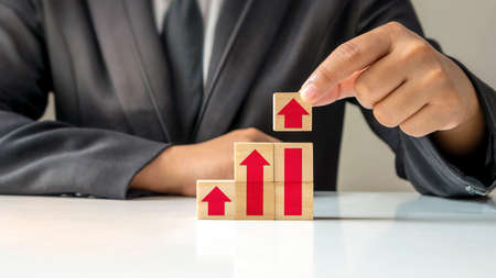 Profitability Concept for Business and Financial Growth. The grip of the wooden cube with the arrow icon is steadily increasing.の写真素材