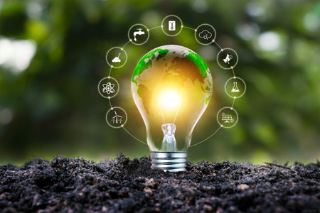 A light bulb with a green world map symbolizes renewable and sustainable energy sources for environmental protection.の写真素材