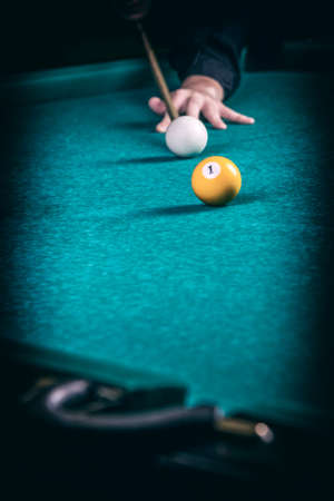 Close up of a man playing billiard. Playing billiard game background.の写真素材