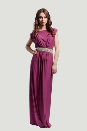 Beautiful female fashion model posing in purple dressの写真素材
