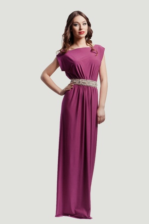 Beautiful female fashion model posing in purple dressの写真素材