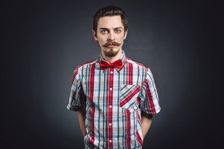 Man in plaid shirt and bow tie in the studioの写真素材