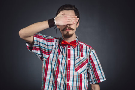 Man in plaid shirt and bow tie in the studioの写真素材