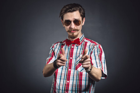 Man in plaid shirt and bow tie with glasses in the studioの写真素材