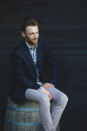 Man in a jacket sitting on a barrelの写真素材