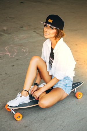 Fashion lifestyle, beautiful young woman with longboard.   の写真素材