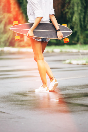 Fashion lifestyle, beautiful young woman with longboard.    の写真素材