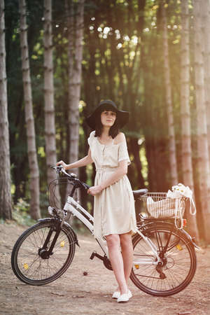 Girl on a bicycle in coniferous forestの写真素材