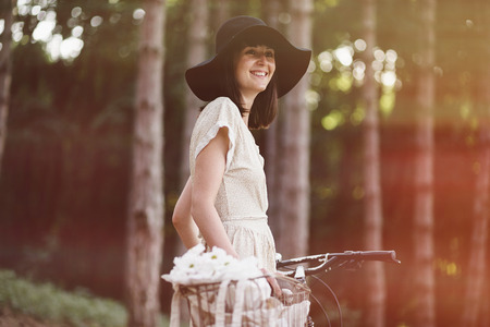 Girl on a bicycle in coniferous forest.の写真素材