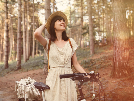 Girl on a bicycle in coniferous forest.の写真素材