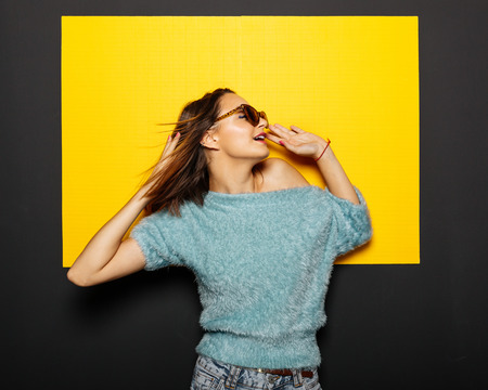 Smiling girl in glasses on yellow backgroundの写真素材