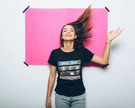 Cheerful girl in casual clothes posing at cameraの写真素材