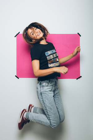 Cheerful girl in casual clothes posing at cameraの写真素材