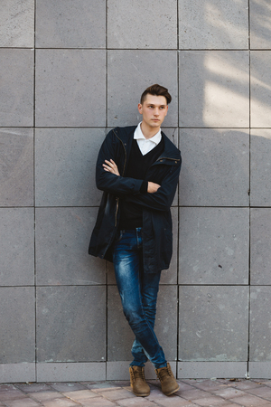 Fashion hipster male model posing and holding a bag posing outdoorの写真素材