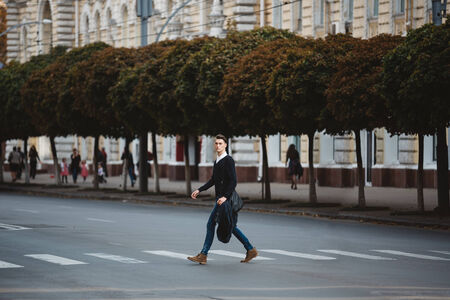 Young man cross the street at a crosswalkの写真素材