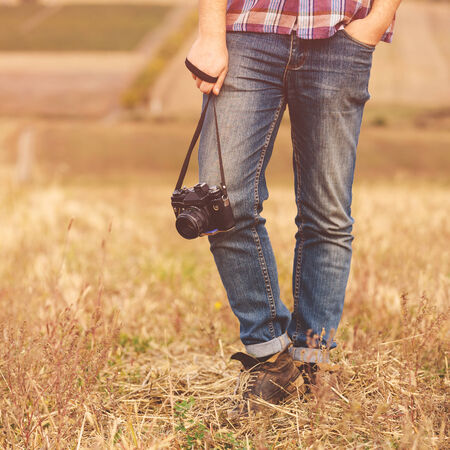 Young Man with retro photo camera outdoor hipster Lifestyle. Film effect
