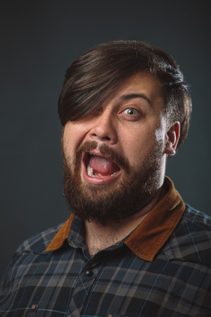Guy in a plaid shirt fooling around over black backgroundの写真素材