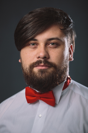 Portrait of a guy in white shirt with red tie bowの写真素材
