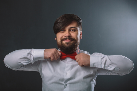 Portrait of a guy in white shirt with red tie bowの写真素材