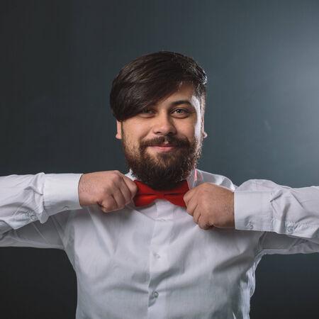 Portrait of a guy in white shirt with red tie bowの写真素材