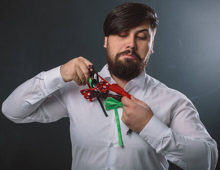 Portrait of a guy in white shirt with colorful bow tiesの写真素材
