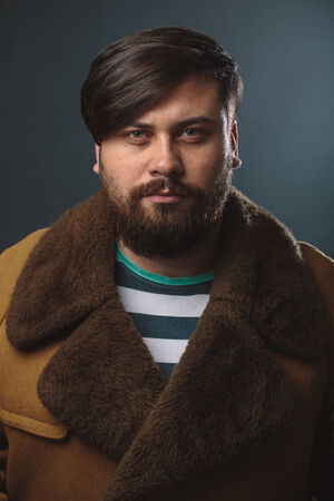 Guy in fur coat studio portraitの写真素材