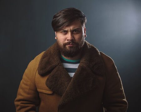 Guy in fur coat studio portraitの写真素材