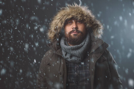 Handsome bearded man in snow stormの写真素材