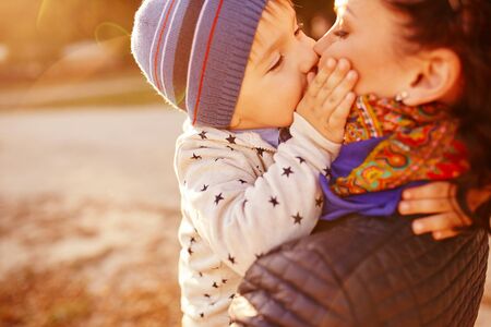 Mom and son having fun by the lake. Warm filter and film effectの写真素材