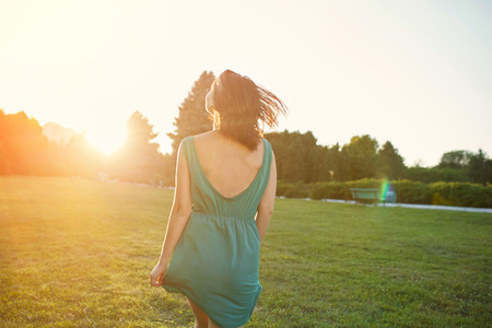 Beauty romantic woman walking in the park at sunset. Sunlight effectの写真素材