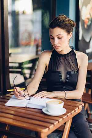 attractive girl with a notepad in the cafeの写真素材